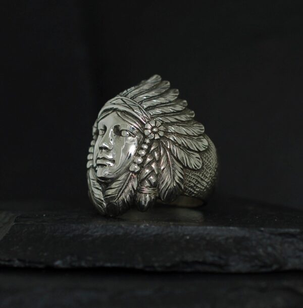A silver ring featuring a detailed Native American chief's head with a feathered headdress.
