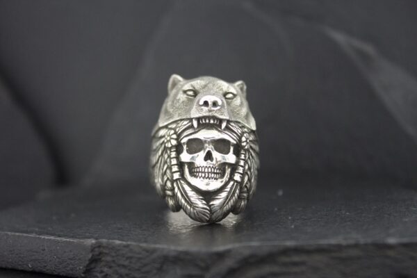 A silver ring featuring a skull wearing an animal headdress.