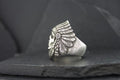 Silver ring with a detailed Native American headdress design.