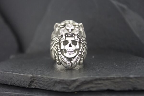 Silver ring featuring a skull inside a lion's head design.