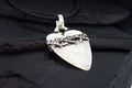 Heart-shaped pendant with a barbed wire design on a black cord.