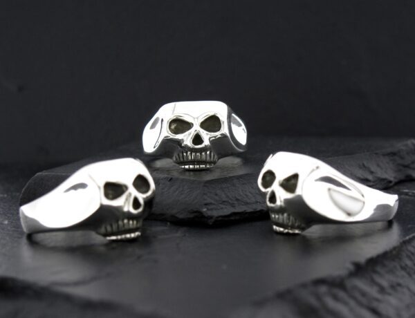 Three skull-shaped objects with black and white patterns on a black surface.