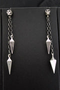 Pair of silver pendulum earrings with chain links on black background.