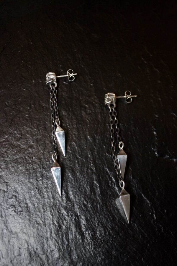 Pair of silver dangling earrings with geometric spike designs.