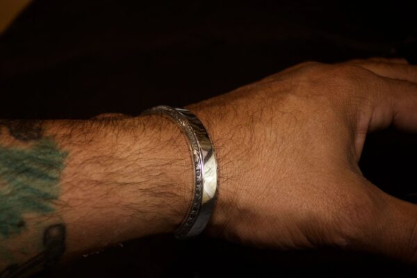 Close-up of a wrist wearing a silver bracelet.
