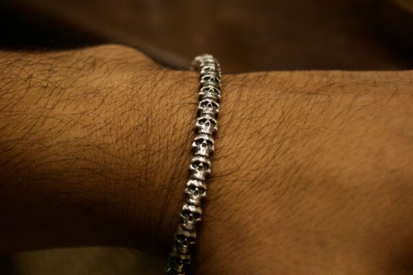 Silver skull chain bracelet on wrist.