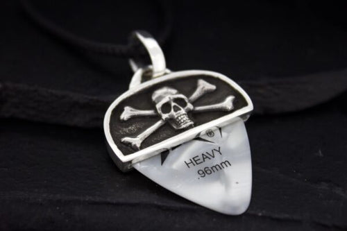 A guitar pick holder with a skull and crossbones design containing a heavy 0.96mm pick.