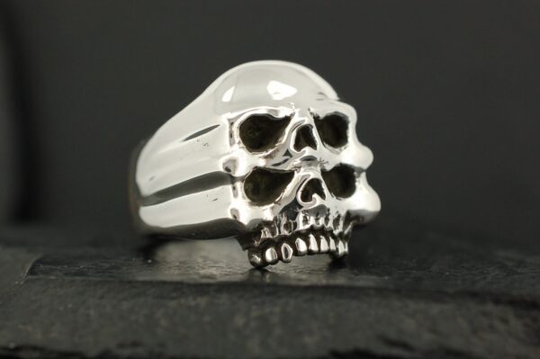 Silver ring with two stacked skull designs.
