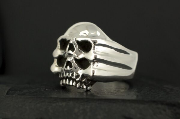 A silver ring shaped like a detailed skull with hollow eyes and nose.