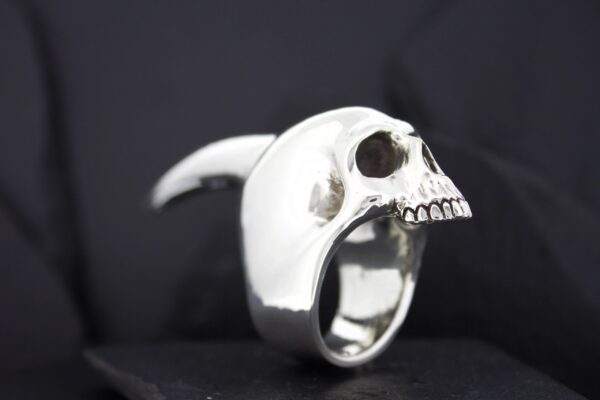 A silver ring shaped like a detailed human skull.