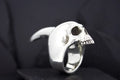 A silver ring shaped like a detailed human skull.