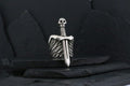A silver dagger with a skull-shaped handle on a dark background.