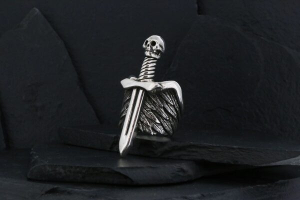 A silver sword pendant with detailed wings on a black background.