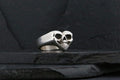A silver ring shaped like a skull with heart-like features.