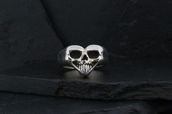 Silver ring shaped like a skull with detailed teeth.