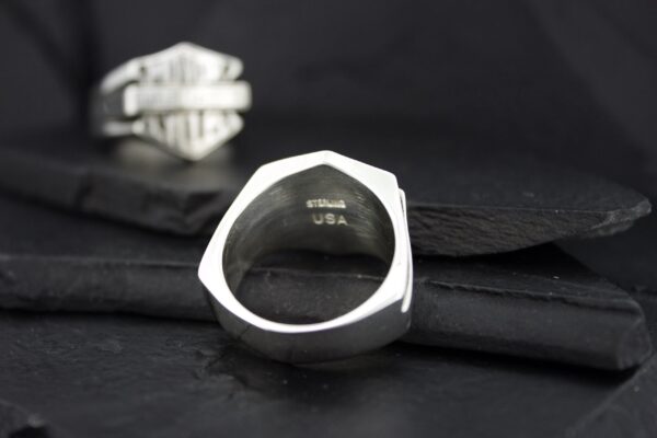 Silver ring with engraved text on the inner band.