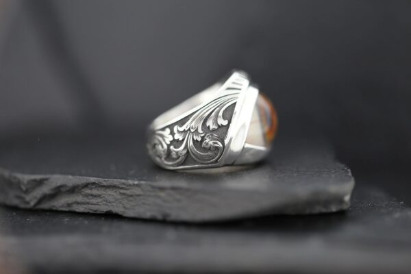 Intricately designed silver ring with detailed floral engravings.