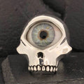 A skull-shaped ring with a realistic human eye in the forehead.
