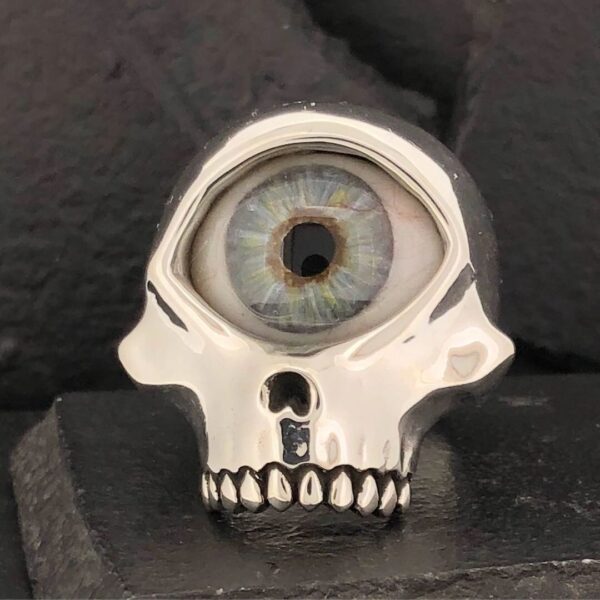 A skull-shaped ring with a realistic human eye in the forehead.