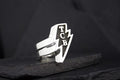A silver ring with a lightning bolt and 'TCB' initials.