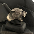 A detailed panther head sculpture with mouth open on a black stand.