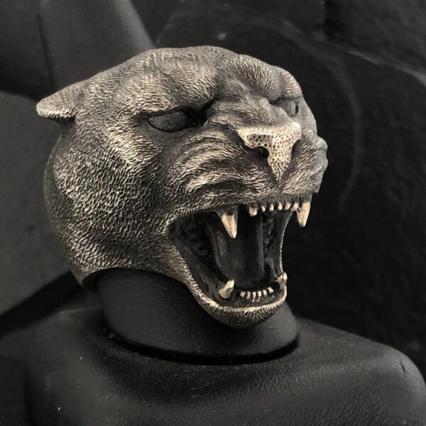 A fierce panther head sculpture with bared teeth and detailed fur texture.