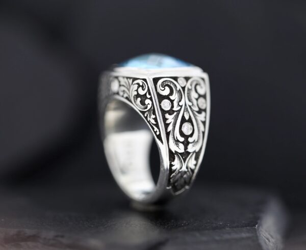 Intricately designed silver ring with ornate patterns.
