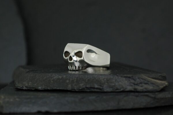 A silver skull-shaped ring with hollow eyes and nose holes.