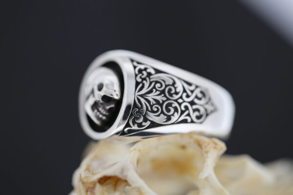Intricately designed silver ring with a detailed pattern.