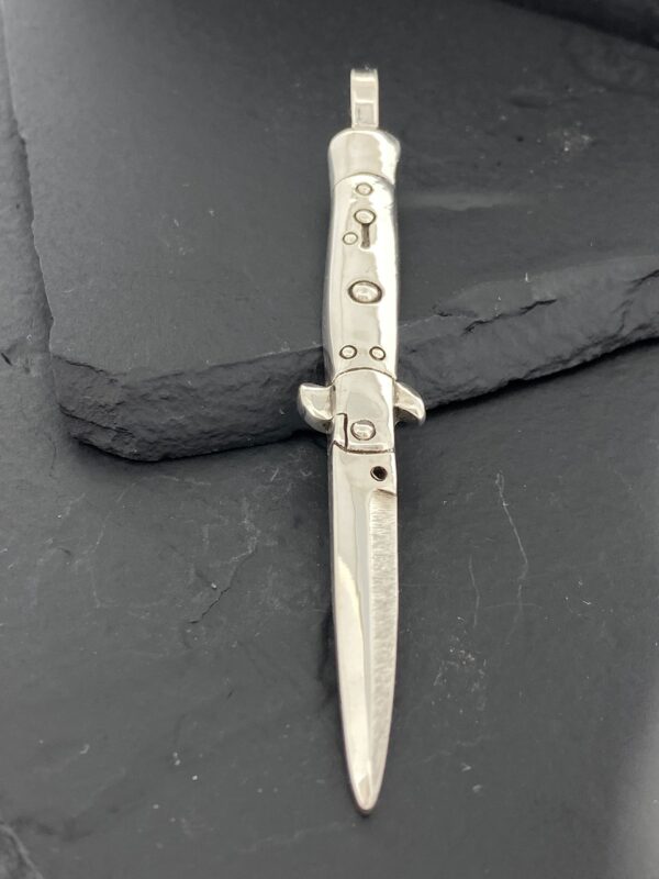 Vintage switchblade knife with a metallic handle and blade.