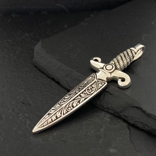 Intricately designed ornamental dagger with detailed patterns on the blade and handle.