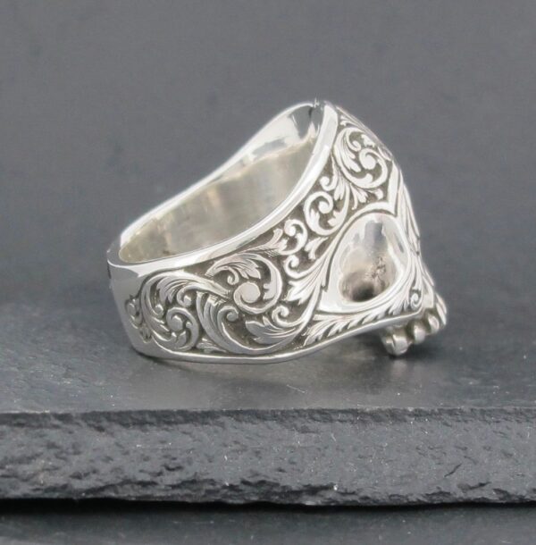 Intricately designed silver ring with ornate floral patterns.