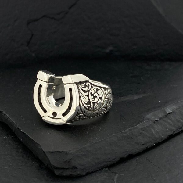 Intricately designed silver ring with a horseshoe motif.