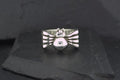 Silver bird-shaped ring with detailed wings on a black surface.