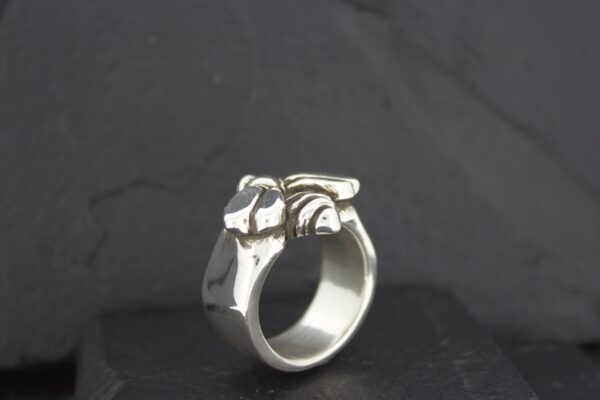 Silver ring designed with an elephant motif on a black background.