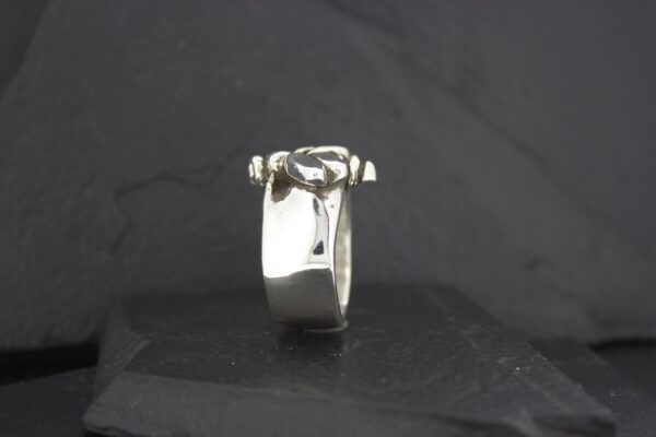 Close-up of a silver ring with a square gemstone.