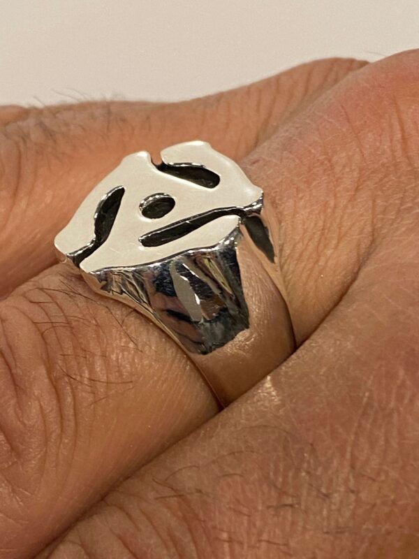 Close-up of a silver ring with a Chinese character worn on a finger.