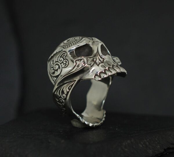 Intricately designed skull-shaped ring with detailed carvings.