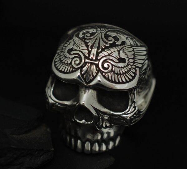 Intricately carved skull with ornate patterns on a dark background.