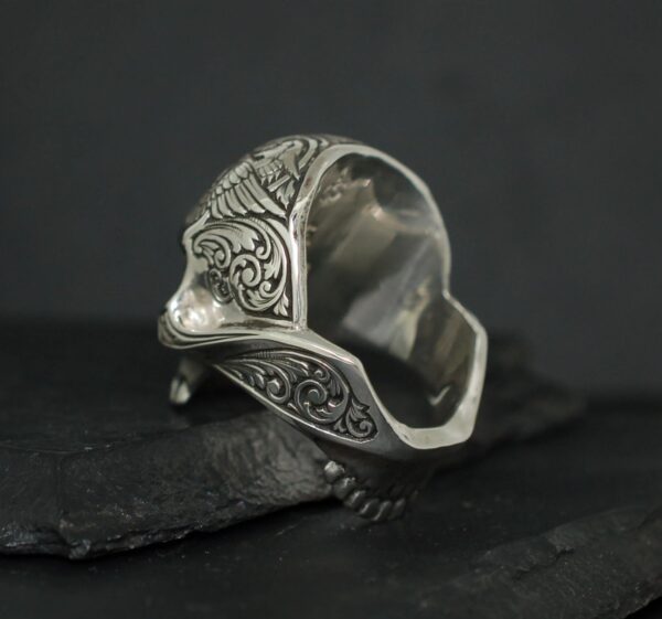 Intricately designed silver ring with ornate patterns.
