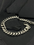 Sleek silver chain bracelet on black background.