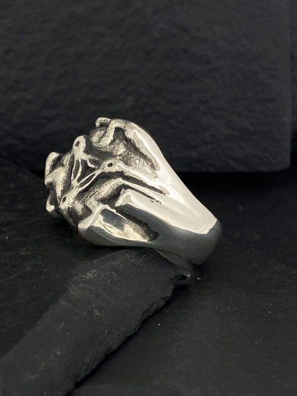Silver ring shaped like a skeletal hand.