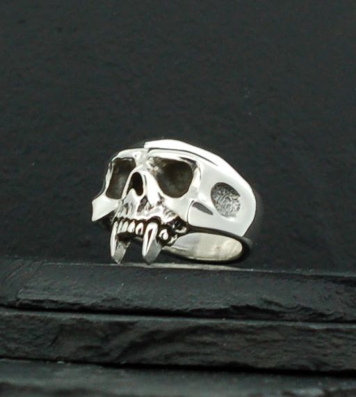 Silver skull ring with detailed teeth and hollow eyes.