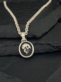 Silver pendant necklace with a skull and crossbones design.