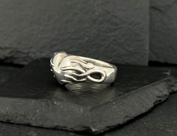 A silver ring with an intricate dragon design.