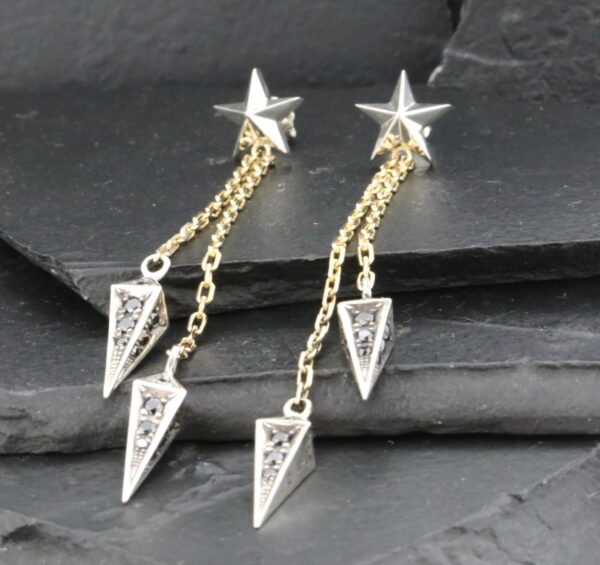 Elegant silver star earrings with dangling geometric pendants.