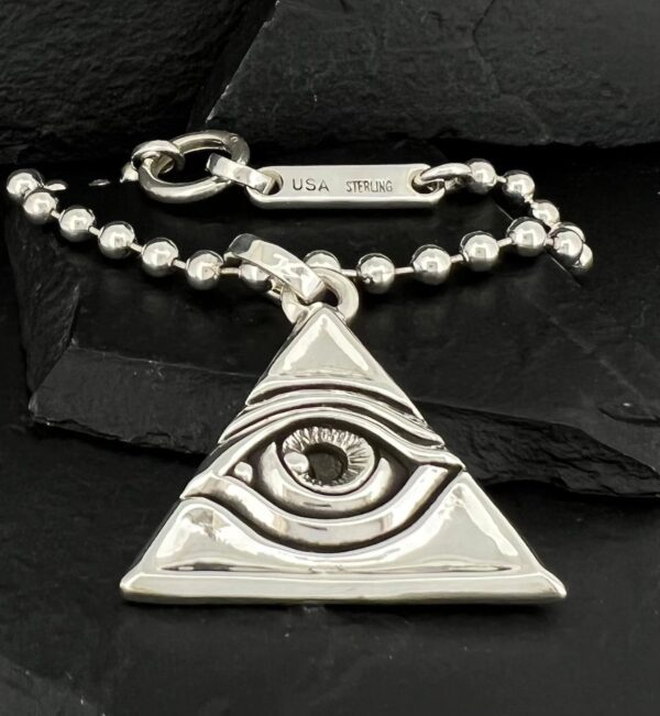 Silver keychain with an eye inside a triangle design.