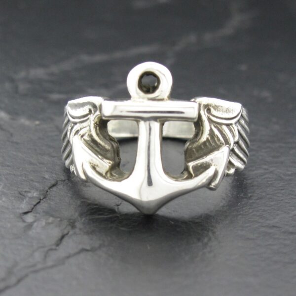 Silver anchor ring with rope details on a dark background.