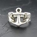 Silver anchor ring with rope details on a dark background.
