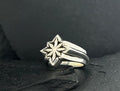 Elegant silver ring with a star-shaped design on top.